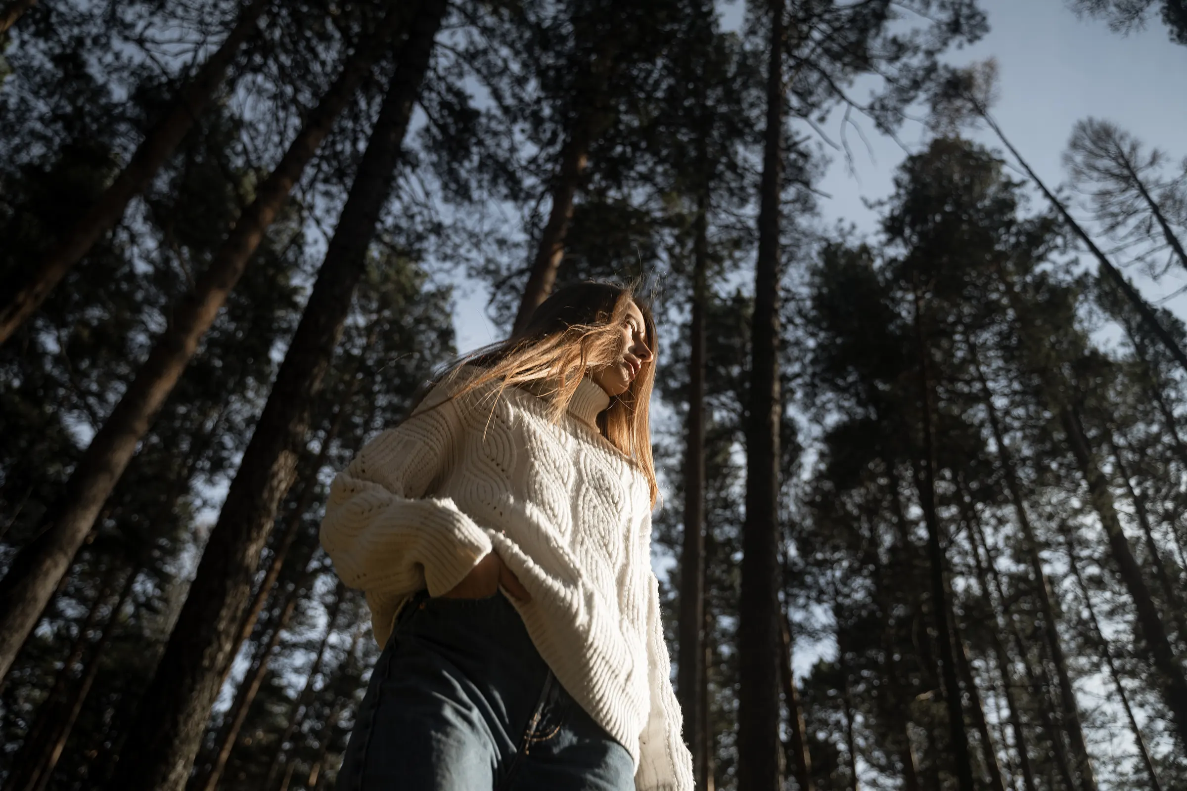 Mulher contempla as copas das árvores na floresta
